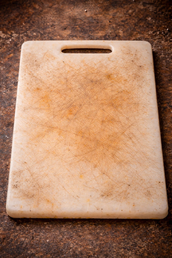 Plastic cutting board on a rustic wooden surface